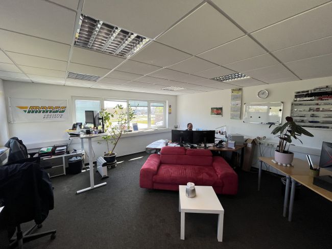 Büro mit Schreibtischen und einem roten Sofa